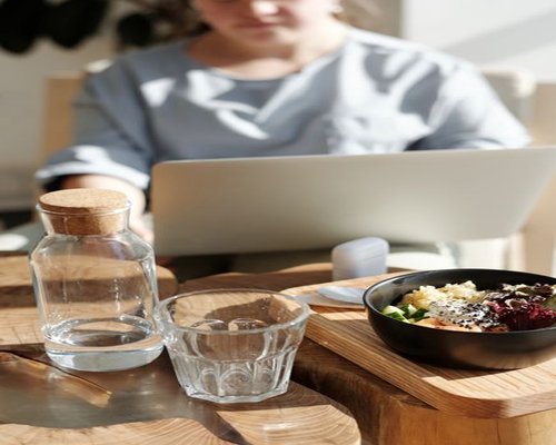 A person working from a cafe in Roma Norte with a glass of water nearby